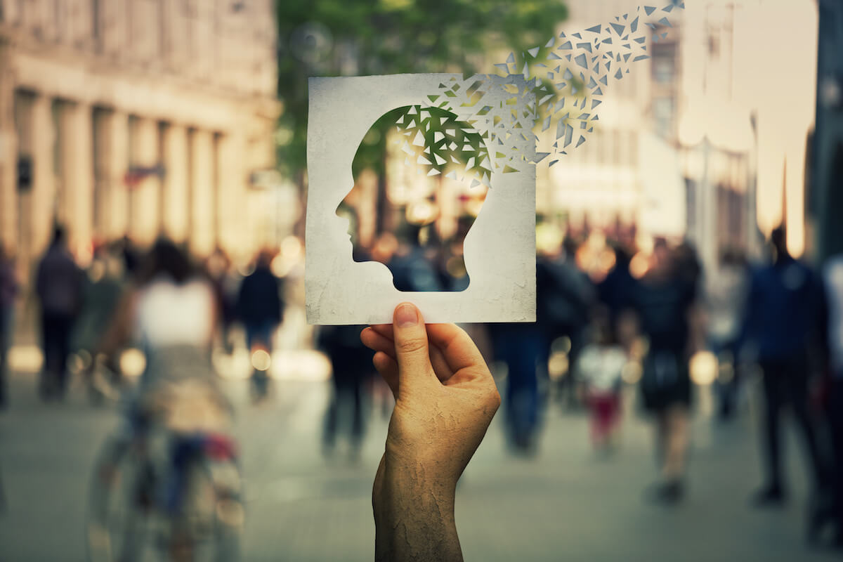 Standing in a crowd holding a silhouette of a face in profile_Bella Groves